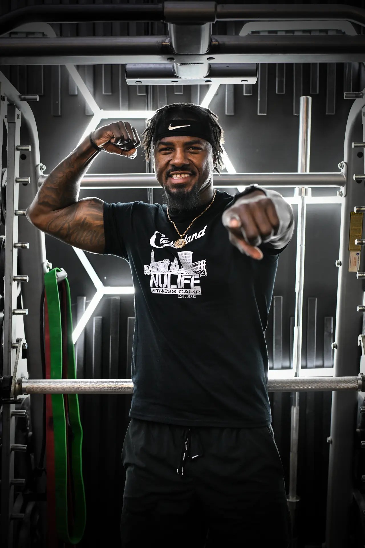 NuLife trainer flexing an arm and pointing toward the camera
